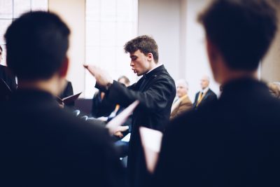 The organ scholar conducts Exeter College choir at Cohen Quad