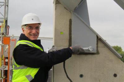 Sir Ronald Cohen tightens a bolt at the topping out ceremony