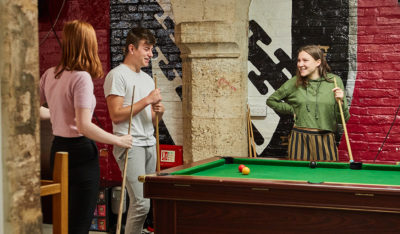 Students playing pool in the undercroft