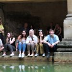A group of +Exeter College Summer Programme Students near a Roman Bath