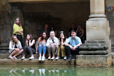 A group of +Exeter College Summer Programme Students near a Roman Bath