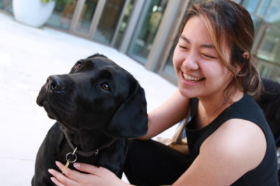 Exeter College Summer Programme Student smiling with a black Labrador