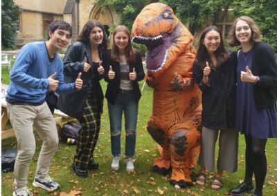 Exeter's Giving Day mascot TRexeter with students in the Fellows' Garden
