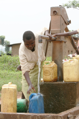 Person pumping fresh drinking water in Rwanda
