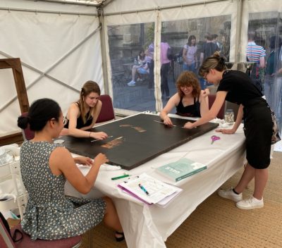 Momoko Okuyama, Jessie Carter, India Ferguson, and Rebekka Katajisto surface cleaning the Portrait of Edwin Lankester