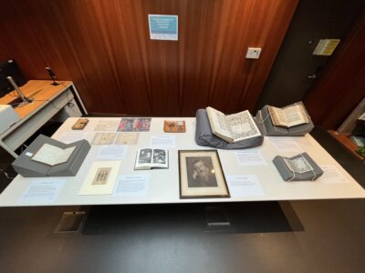 A display of William Morris-related books, manuscripts, photographs and archival material from Exeter College’s Special Collections, arranged on a table for the ‘Hidden Strengths’ exhibition.